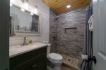Shared Guest Bathroom with Stone Tile Shower